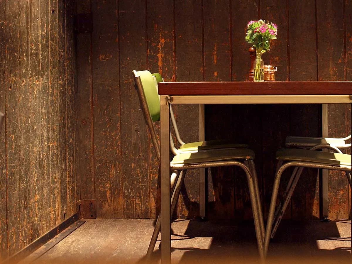 Specialty latte art on dark wooden table with flowers